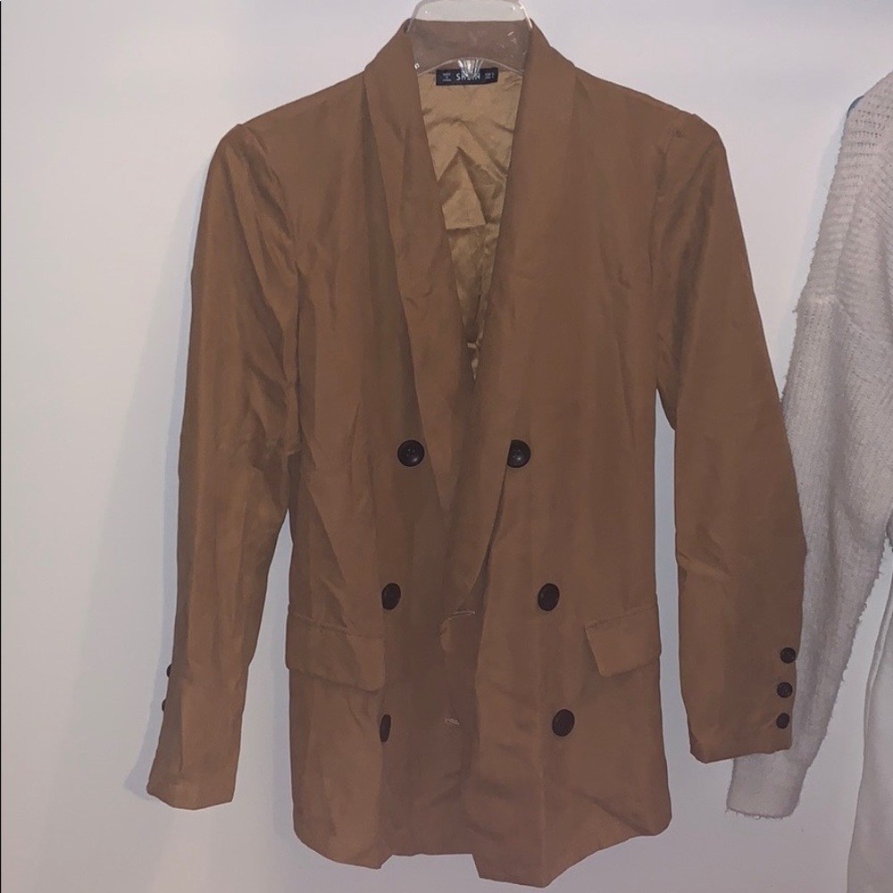 Khaki colored trench coat with black buttons